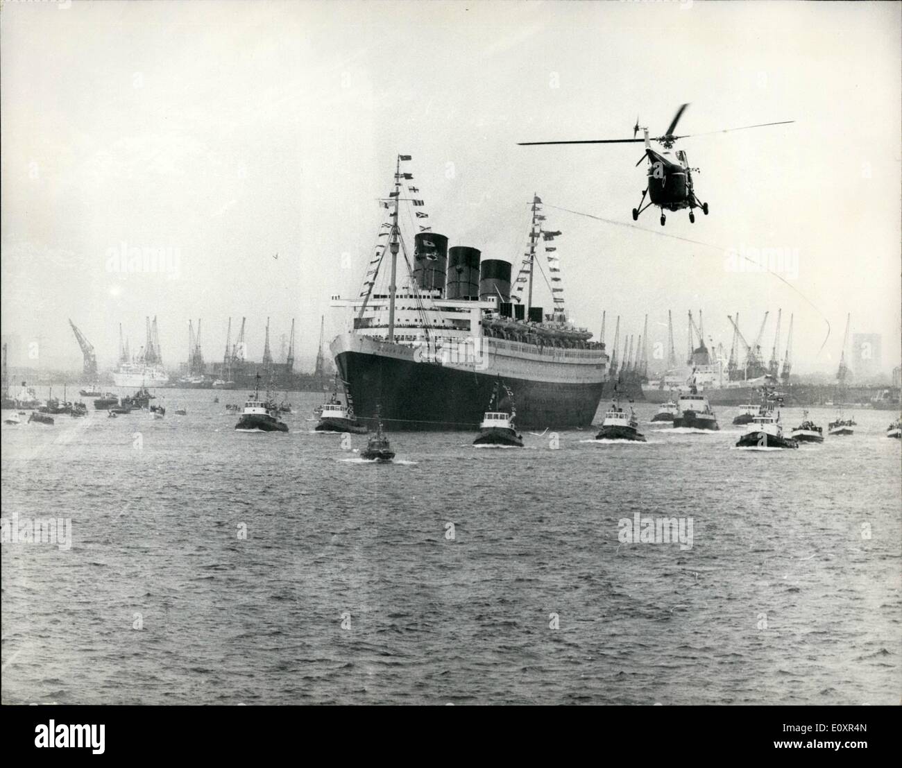 10 octobre 1967 - Queen Mary quitte Southampton le dernier voyage. Les 81 000 tonnes liner Queen Mary a reçu un grand coup lorsqu'elle a quitté Southampton aujourd'hui sur son dernier voyage. Au cours de ses 39 jours de croisière, le Queen Mary naviguera Caps ronde corne sur son chemin à Long Beach, Californie, où elle deviendra un musée maritime et un centre de congrès. Photo montre avec un hélicoptère volant à everhead, le Queen Mary avec tuga et une flottille de petits navires, est vu comme elle part de Southampton pour son dernier voyage aujourd'hui. Banque D'Images