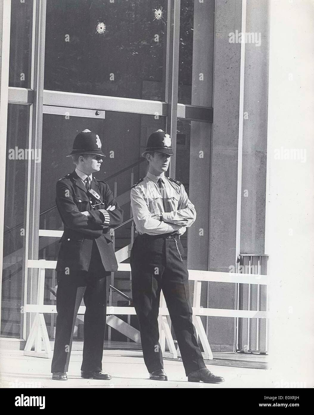 Août 21, 1967 - Londres, Angleterre, Royaume-Uni - deux policiers montent la garde à l'extérieur de l'ambassade des Etats-Unis après un homme d'armes à feu inconnu perçaient les fenêtres et portes de la plaque du fonctionnaire consulaire. Banque D'Images