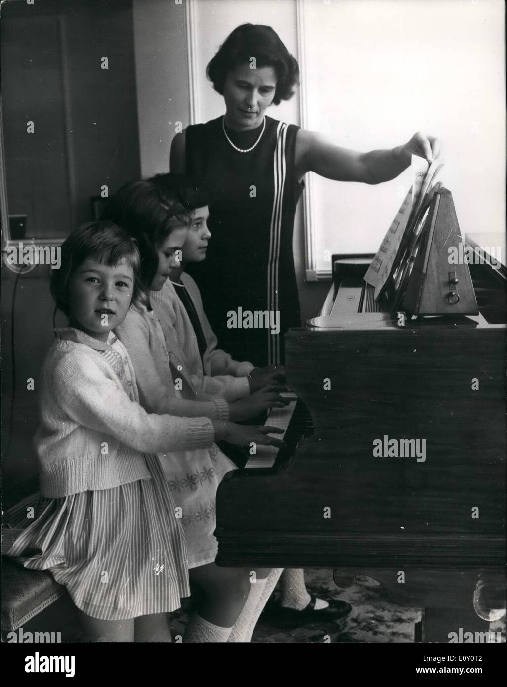 Mai 05, 1968 - épouse de membre de l'équipe de transplantation cardiaque à la maison ; tandis que M. Donald Longmore, le physiologiste et membre de l'équipe qui a effectué la première greffe du coeur opération a été à l'Hôpital National Du Cœur, Marylsbone aujourd'hui - son épouse, Patricia, qui est physiothérapeute de Montréal, au Canada, et leurs trois enfants, Juliette 8 10 Annabel et Susan, 5 étaient à leur domicile à Staines, Middlesex. Photo montre Mme Patricial Longmore fait tourner les pages de la musique pour filles (L à R) Susan, 5, 8 et Juliette Annable 10, comme ils l'ont joué une mélodie sur le piano, à leur accueil à Staines aujourd'hui. Banque D'Images