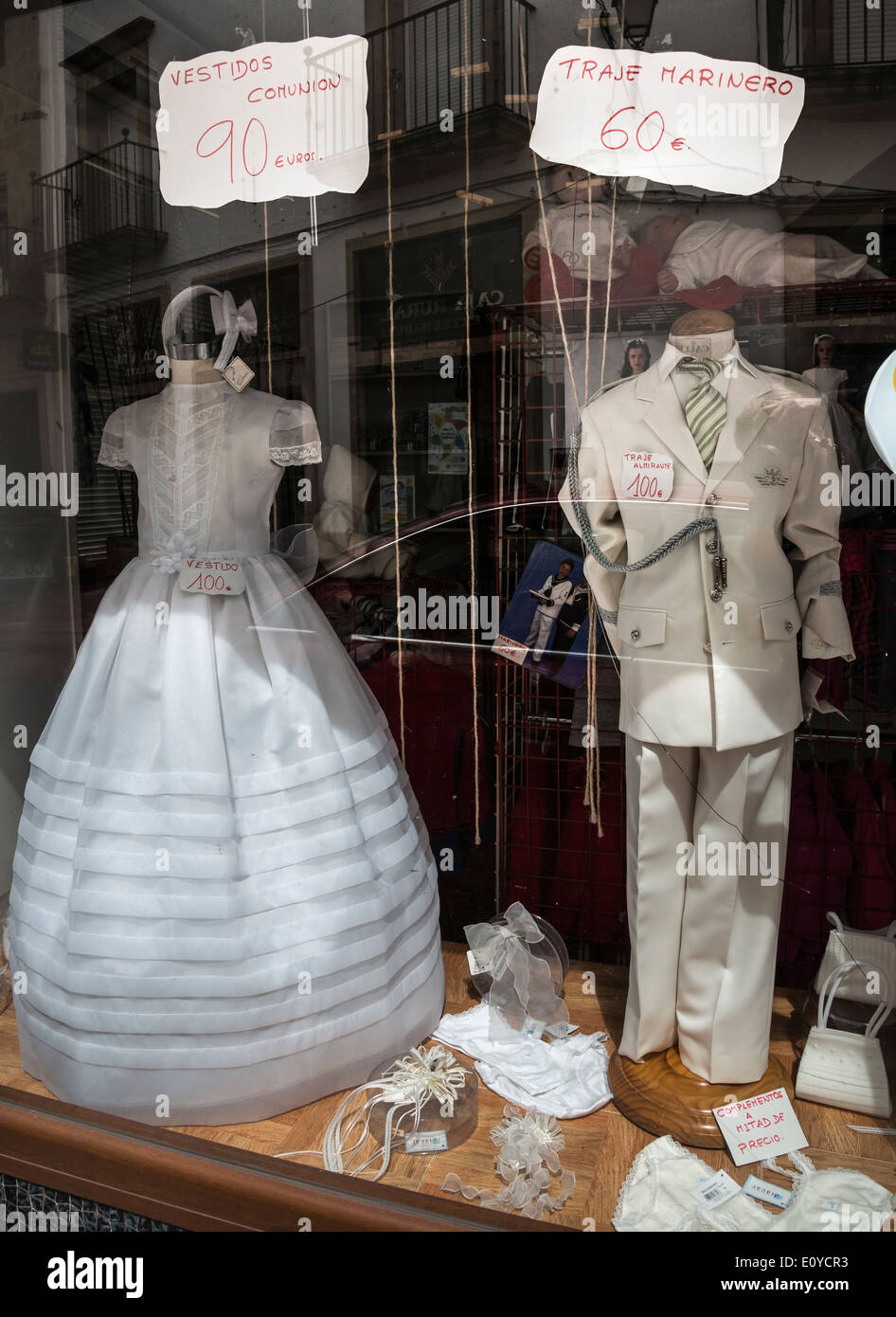 Les vêtements pour enfants de la communion religieuse et d'autres événements officiels dans une vitrine dans Trujillo, Estrémadure, Espagne. Banque D'Images