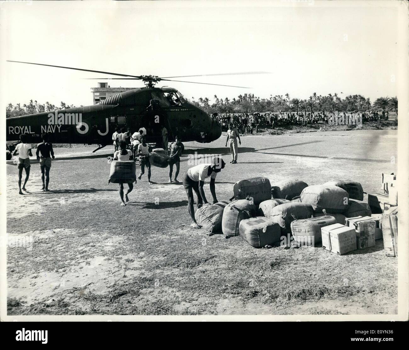 11 novembre 1970 - Bonnes volontés : Patuikhali, à l'Est du Pakistan. Les Pakistanais ont été tout à fait disposé à décharger stocke depuis un hélicoptère de la Britain's 847 Naval Air Squadron après qu'il avait atterri à Patuikhali avec des fournitures de secours pour les survivants du cyclone du Pakistan catastrophe. L'hélicoptère a volé dans le navire d'assaut britannique de l'Intrepid, un des quatre navires de services combinés de la task force, qui l'ancre dans la baie du Bengale, novembre 245e, pour commencer l'exploitation de la toile de jute pour le soulagement des survivants du cyclone. Banque D'Images