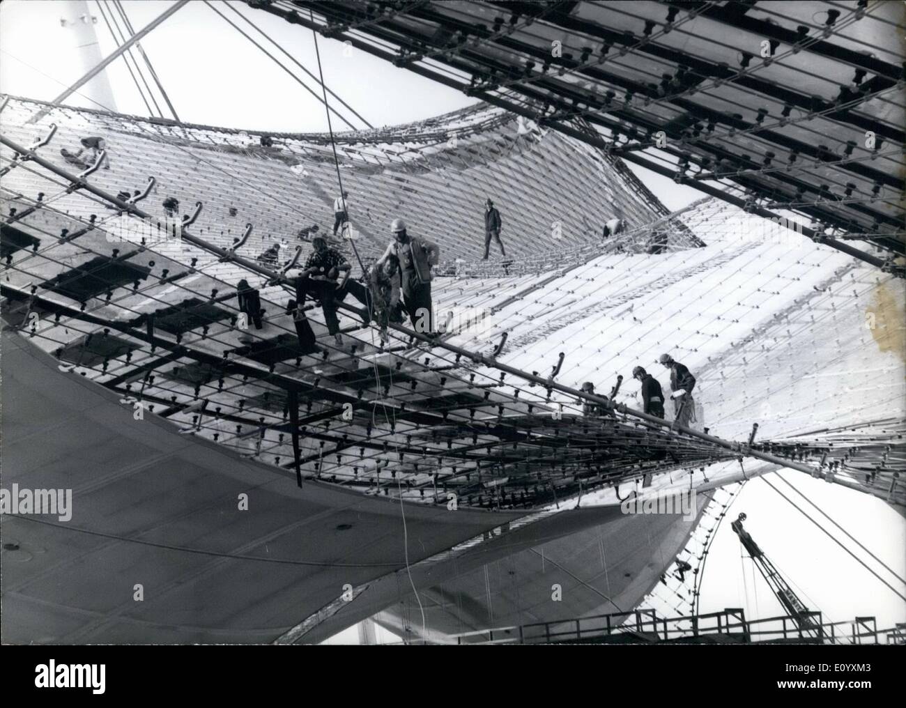 10 octobre 1971 - Les travaux sur le plus grand toit du monde.. : sont toujours en cours. Les travailleurs ont à donner des spectacles dans l'artistique presque ''net'' des Jeux Olympiques parce que le toit de la mise en panneaux transparents est travail dur et des besoins de compétences. Banque D'Images