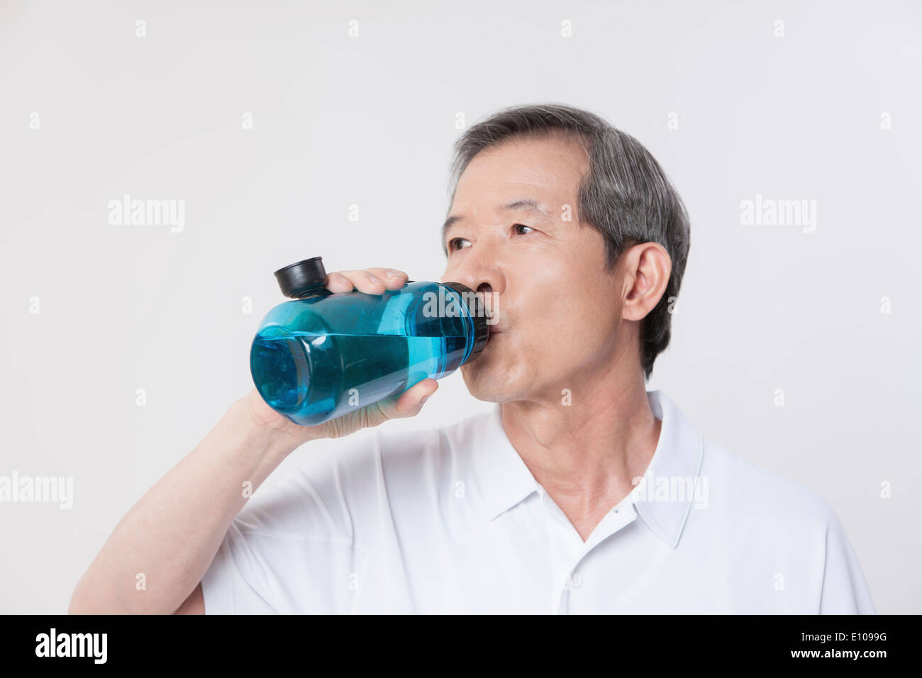 Un vieil homme l'eau potable à partir d'une bouteille Banque D'Images