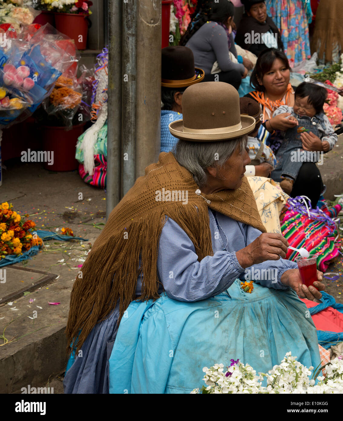 Femme Cholita bolivienne ou gelée de manger à un marché aux fleurs à La Paz, Bolivie. Banque D'Images
