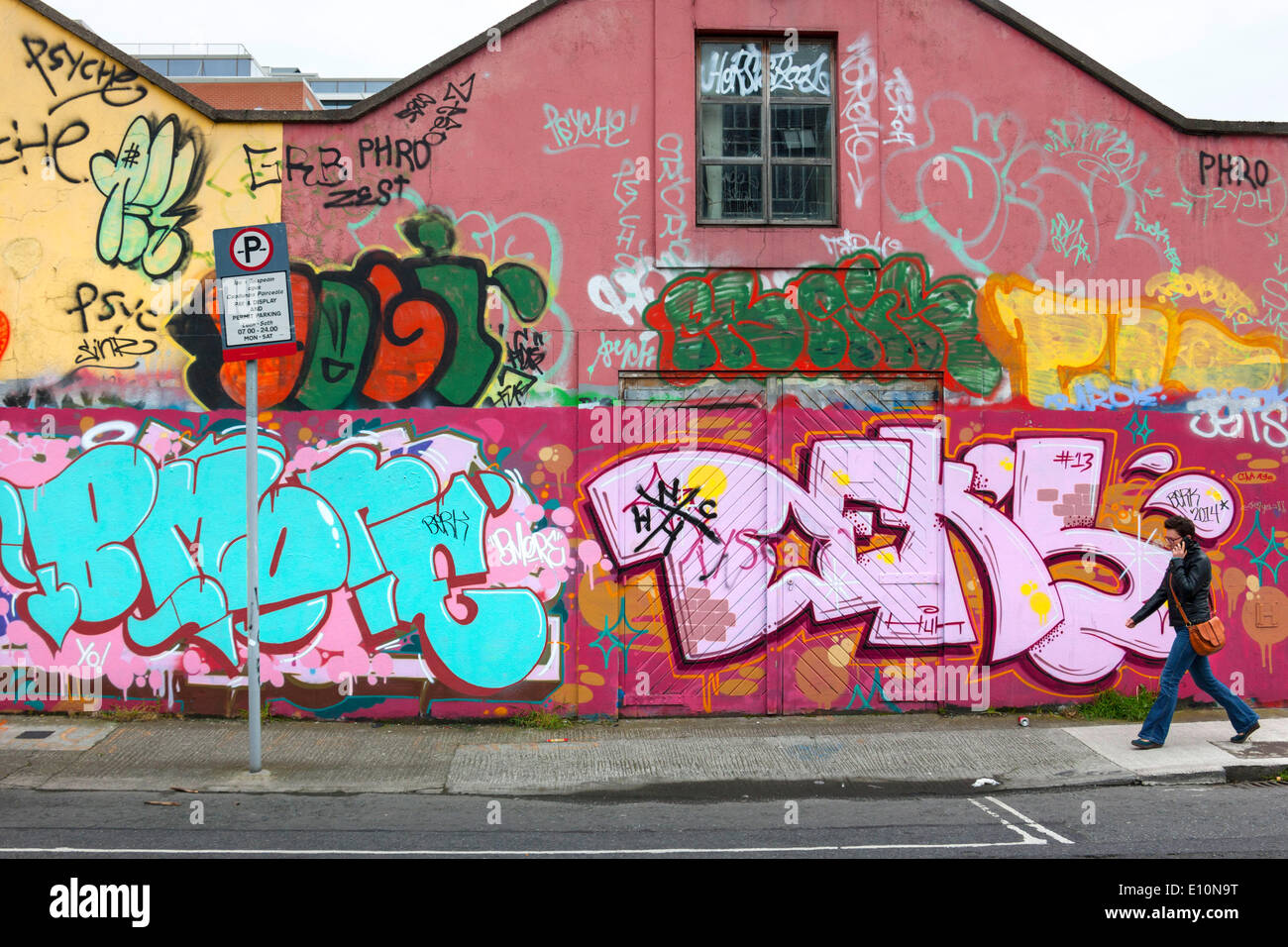 Woman walking in front of Wall Graffiti, Dublin, République d'Irlande, Europe. 02.05.2014 Banque D'Images