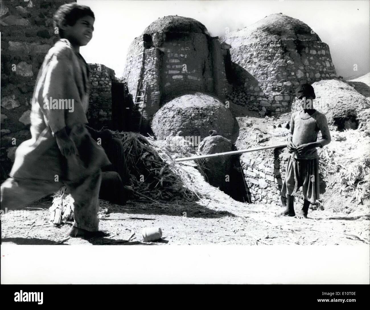 01 janvier 1974 - Poterie arabe traditionnel : ces bâtiments construits étrangement illustrés ici sont en fait l'un des fours de poterie qui produit encore de la céramique pour une utilisation quotidienne et est situé dans la vieille ville quartiers du Caire. Comme il est de coutume, les deux garçons arabes qui ont pris notre photographe attitré, gagnent de l'argent en donnant un coup de main. Après la céramique faite main ont séché à l'air libre pendant plusieurs jours. Ils sont alors prises dans le four par les jeunes aides. Pendant plusieurs jours la poterie est d'être cuits dans des fours puis. Banque D'Images