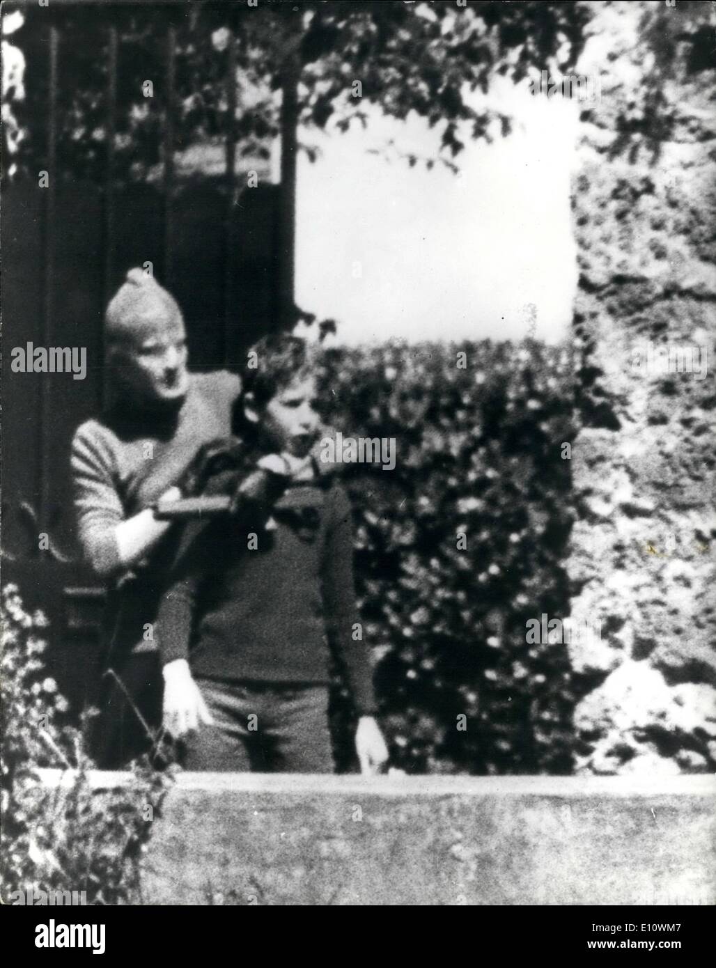 05 mai 1974 - Banque, contrecarré des tireurs de prendre des otages. Des hommes armés qui avaient échoué dans une tentative de raid. une banque à Champigny, une banlieue de Paris où Mme Lacheteau s'occupe de ses cinq enfants et les a détenus en otage. Plus tard, ils sont hors de la maison avec Mme Lachetau et son fils Bruno, et est parti dans une voiture fournie par la police. Plus tard, les otages ont été libérés dans un bois près de Paris. La photo montre le port d'un masque d'ensemencement et de transporter un fusil de chasse, l'un des bandits laisser la maison dans une banlieue de Paris avec les jeunes Bruno, l'un des otages. Plus tard, les otages ont été libérés. Banque D'Images