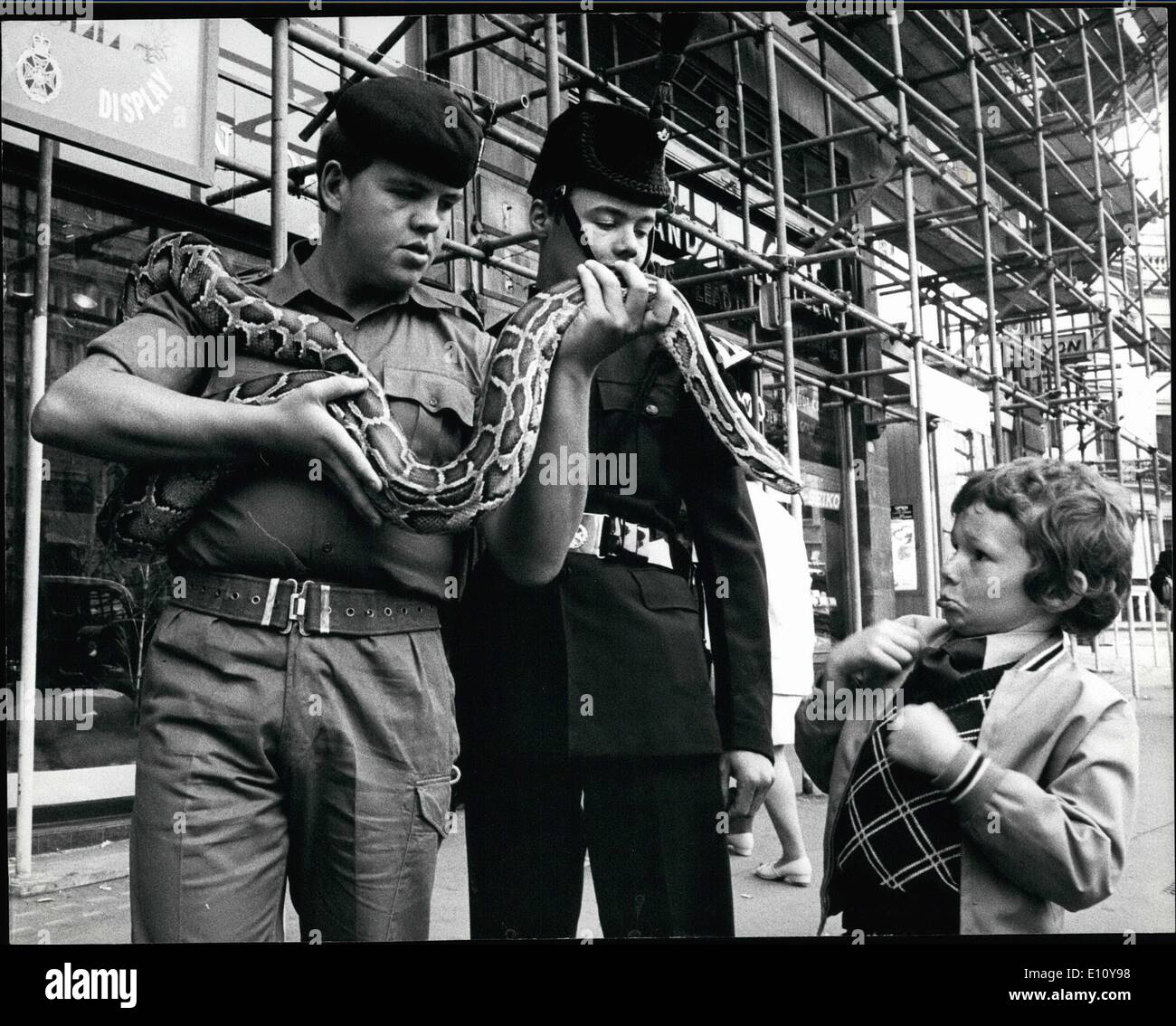 Juin 06, 1974 - Les serpents vivants : 8 ans Richard Watts. de Gloucester ressemble un peu d'appréhension à l'âge de trois ans par Python Rifleman Alan Quinn, Royal Green Jackets, mis à la tête d'être tracé au cours d'une campagne de recrutement de la jungle dans le Strand, London. hier. Le régiment a récemment revenu de la Malaisie. Banque D'Images