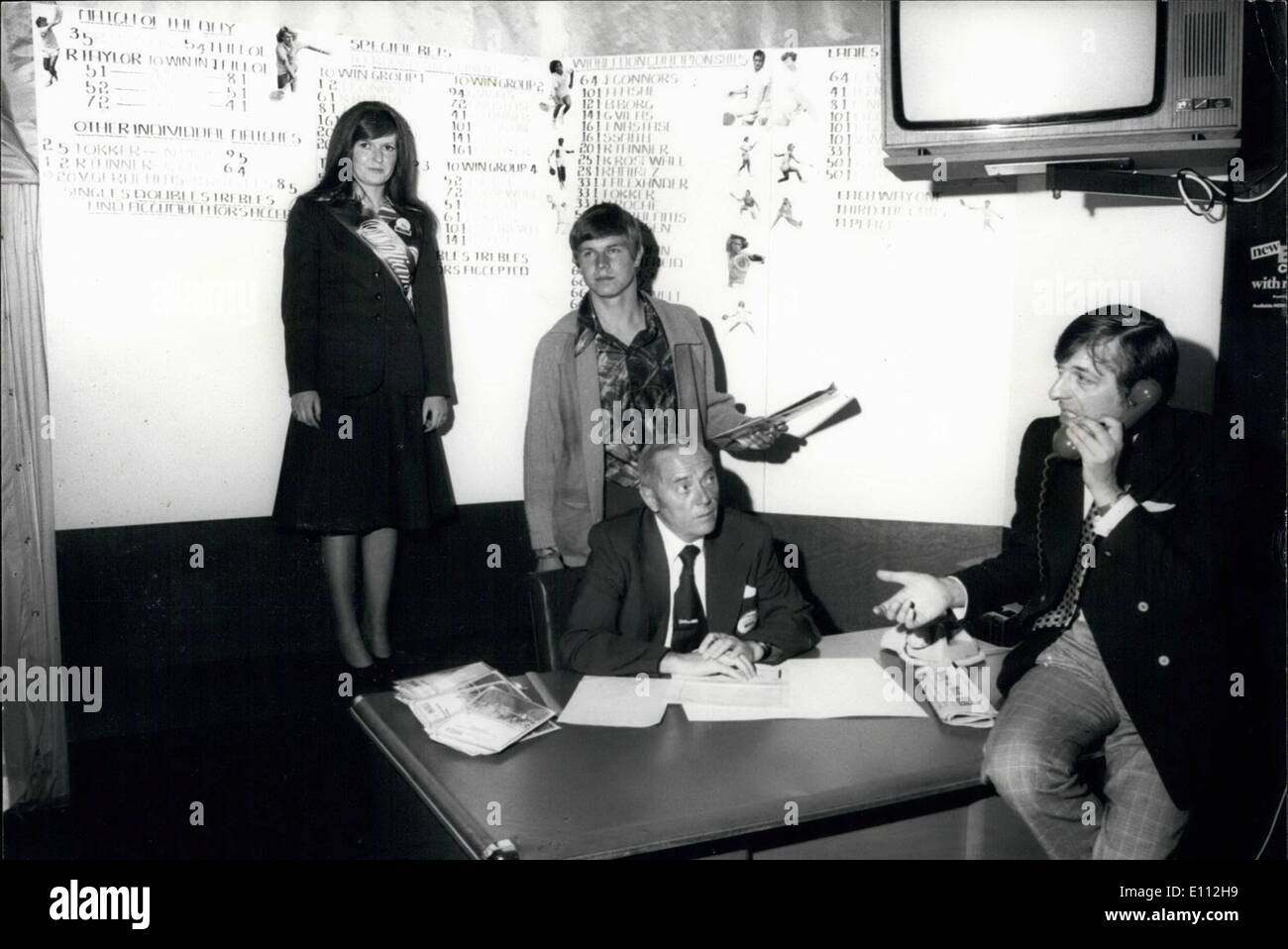 Juin 06, 1975 - le premier Wimbledon : Le stand de Paris William Hill Organisation a mis en place un chapiteau de pari à Wimbledon pour le Tennis Championships qui a commencé aujourd'hui. Photo montre tennis player ''Buster'' Mottram (en arrière-plan), qui a dû se retirer de l'organisation des championnats, répond à l'une de l'essaim de William Hill les filles et offre des conseils sur les paris - dans le cadre de sélection à Wimbledon aujourd'hui. Banque D'Images
