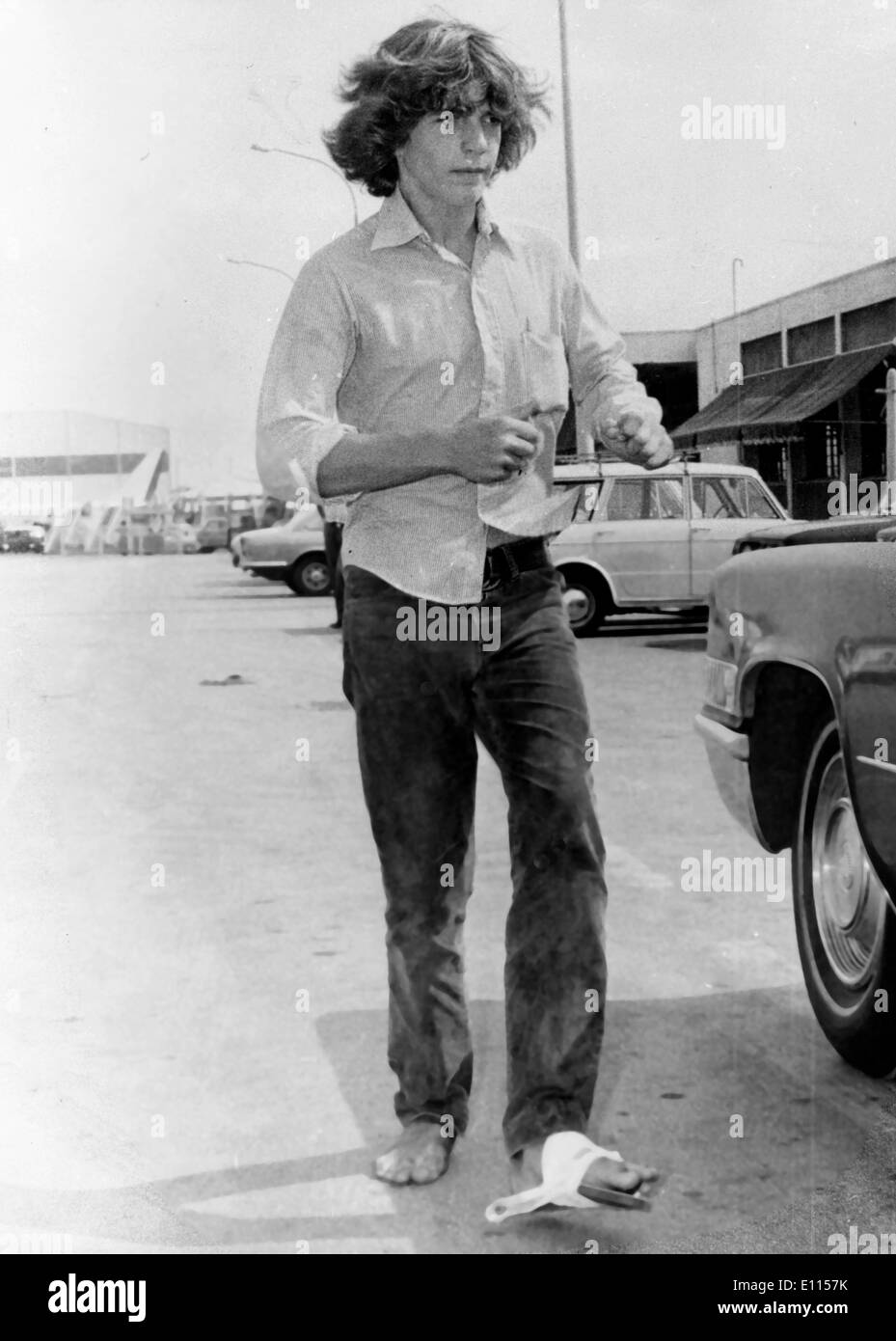 Aug 11, 1975 ; Athènes, Grèce, 15 ans, John Kennedy, le fils de Mme Jacqueline Onassis, ha un accident alors que deth-plongée autour de l'île privée appartenant à Onassis de Scorpios dans la Méditerranée. Amis de la famille a déclaré qu'après une immersion dans l'eau avec ses réservoirs d'oxygène stil sur le dos, son pied a été frappé par un bateau de vitesse de passage. Dans cette image de l'avion promenades John après son arrivée à Athènes pour le traitement de sa blessure au pied. Banque D'Images