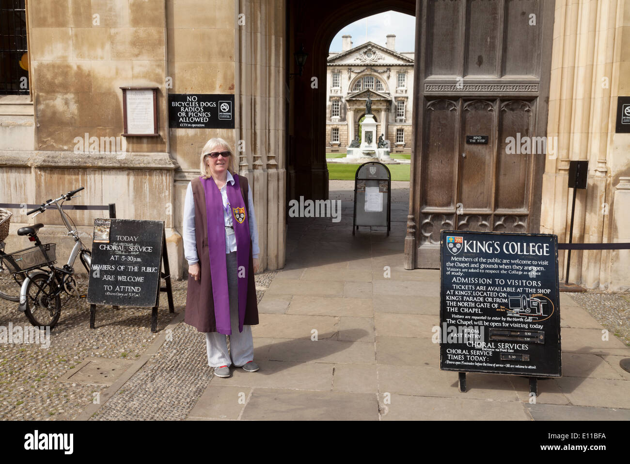 Une femme de porter l'Université de Cambridge à l'entrée de Kings College, Cambridge UK Banque D'Images