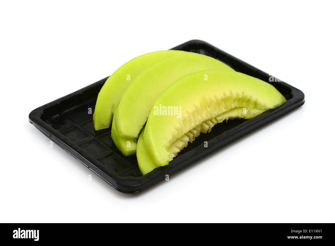 Tranches de melon cantaloup fraîchement coupé sur une plaque noire Banque D'Images