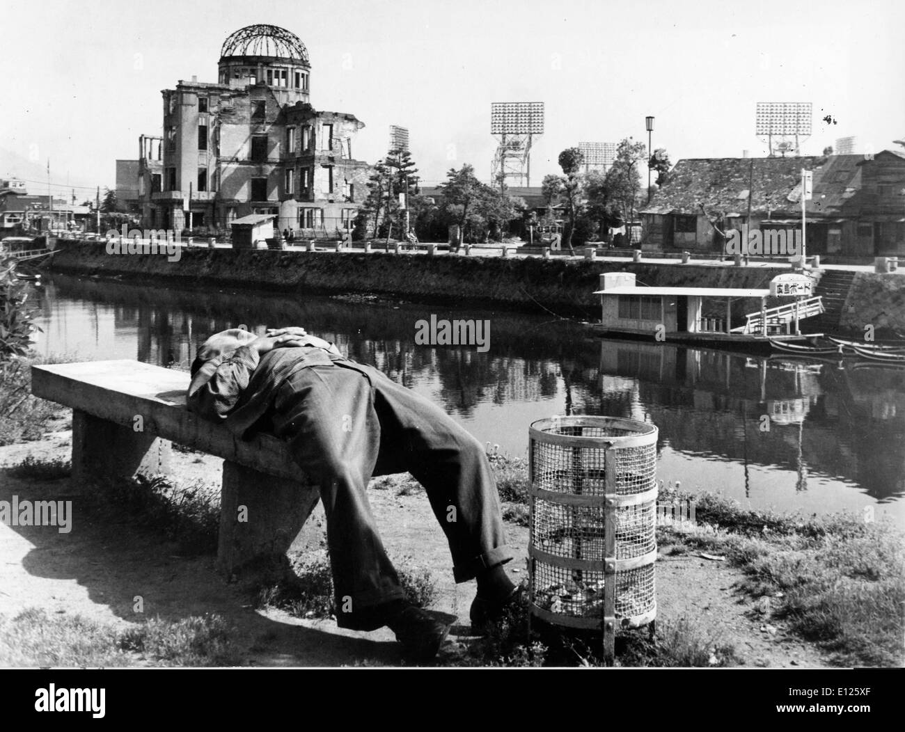 Mar 29, 2006 ; Hiroshima, Japon ; (Photo : date inconnue) un Japonais prend une sieste sur un banc dans le parc de la paix, tandis que l'autre côté de la rivière se trouve les ruines de la galerie d'exposition industrielle qui était juste sous le point d'explosion de la bombe. Alors que le reste d'Hiroshima a été reconstruit, ce bâtiment sera préservé comme un sombre rappel de la catastrophe. (Crédit Image : KEYSTONE/ZUMAPRESS.com) Photos USA Banque D'Images