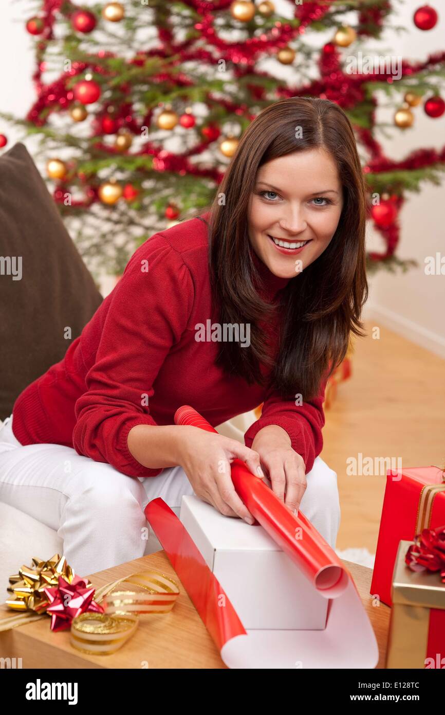 06 octobre 2009 - 6 octobre 2009 - Jeune femme l'emballage cadeau de Noël en face de tree Cr Banque D'Images