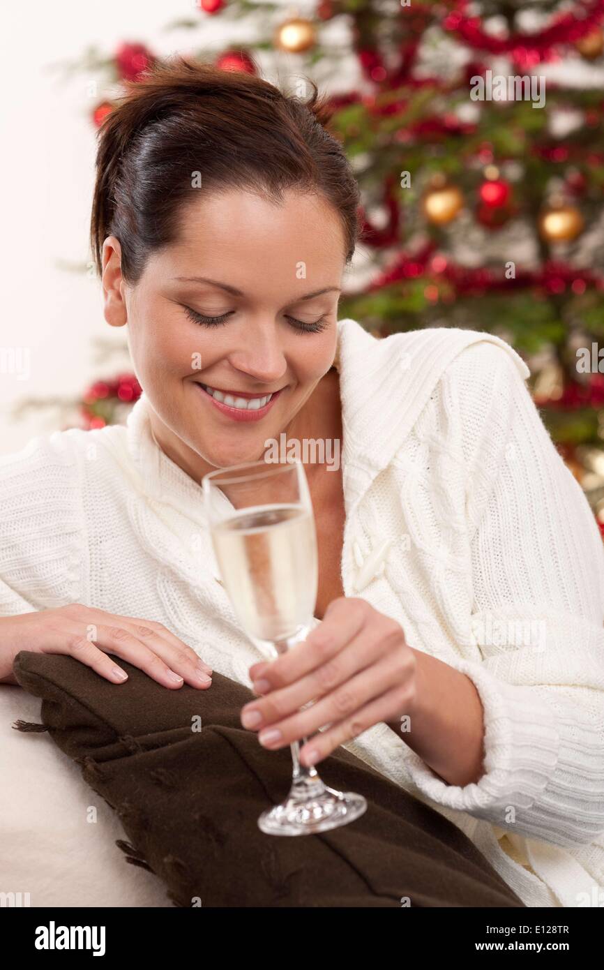 06 octobre 2009 - 6 octobre 2009 - brown hair woman in front of Christmas Tree avec coupe de champagne Banque D'Images