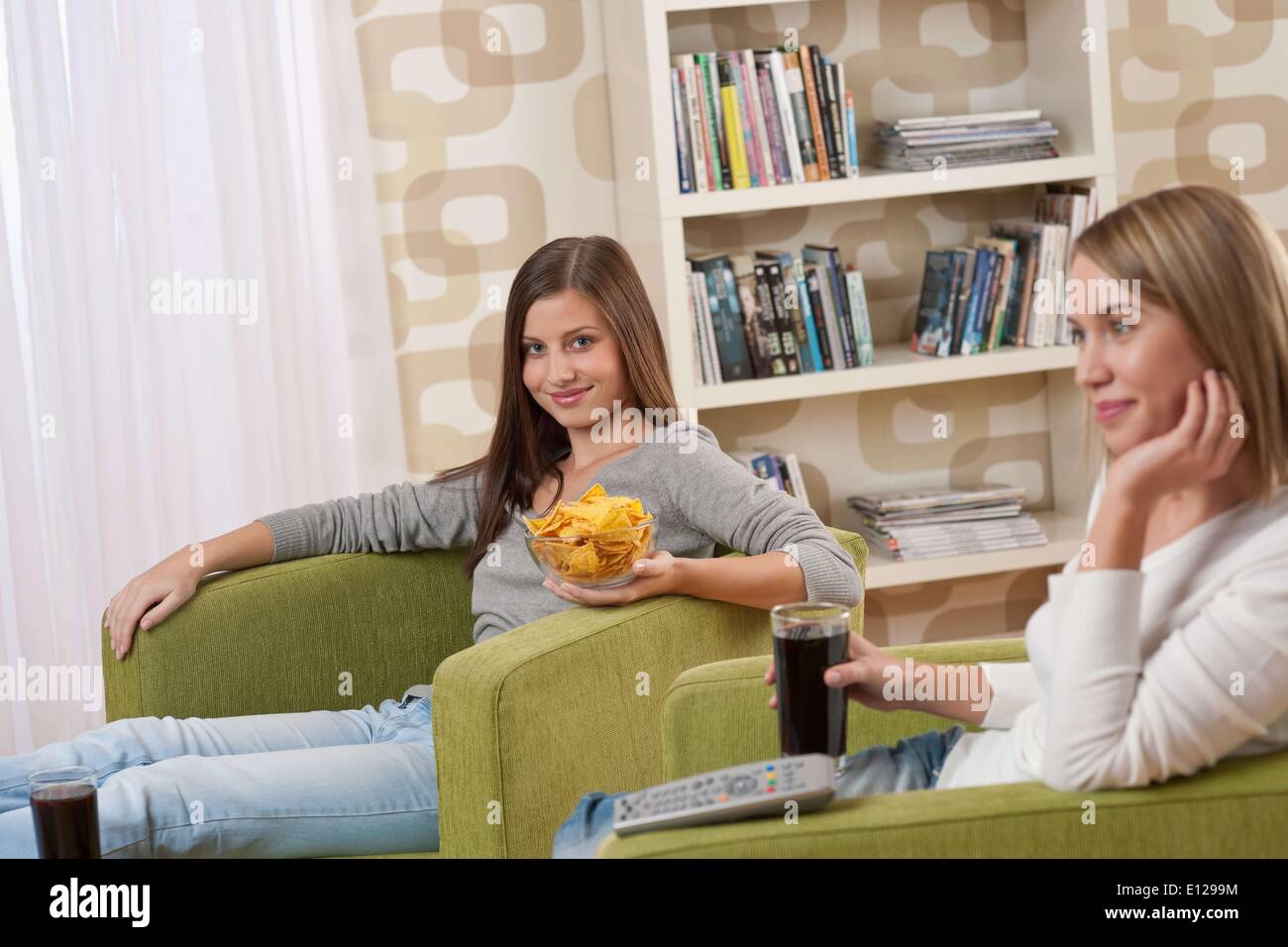 06 novembre 2009 - 6 novembre 2009 - Les Étudiants - Deux female teenager regardent la télévision ensemble, manger des chips Banque D'Images