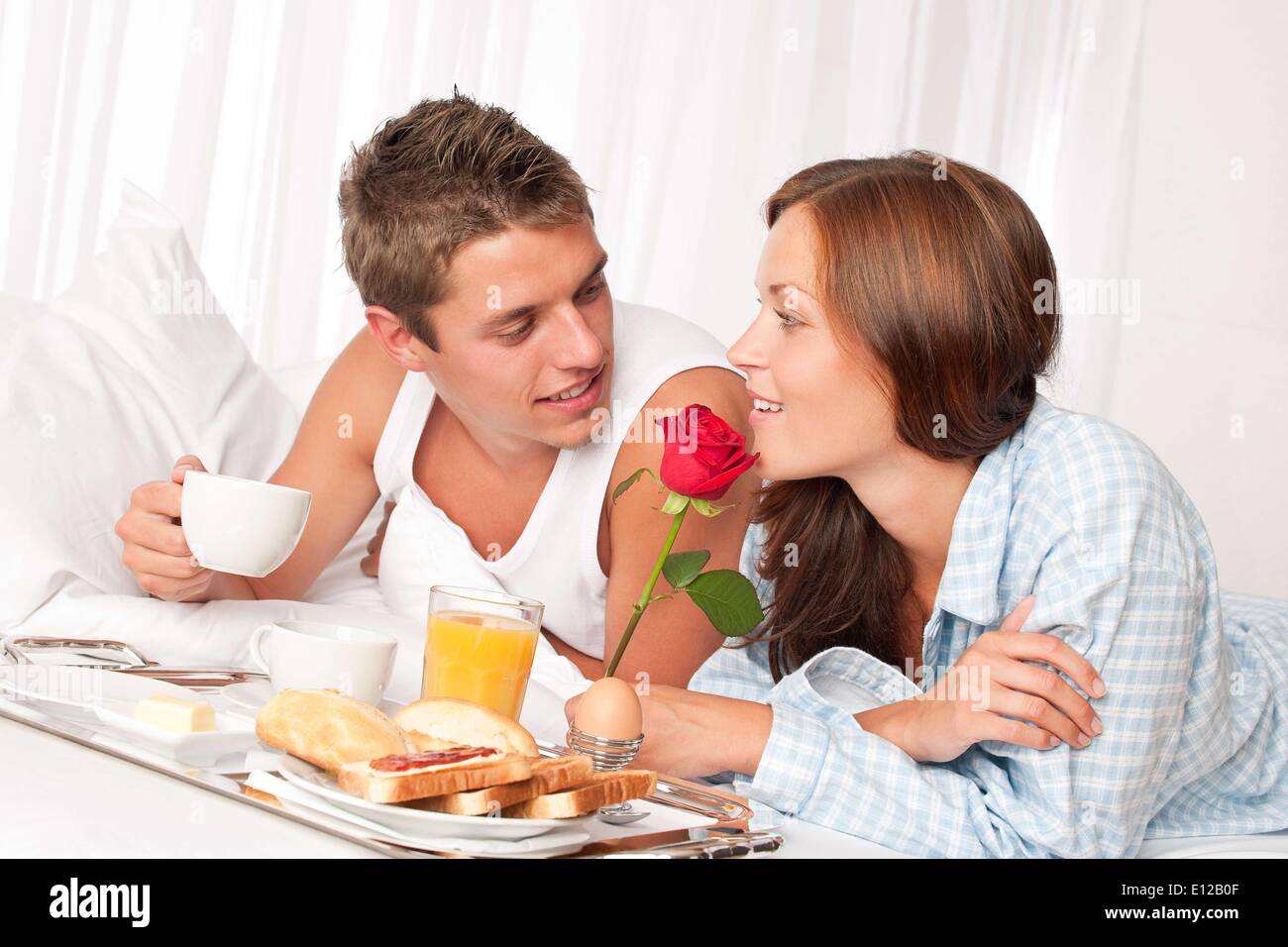 12 août 2009 - 12 août 2009 - Heureux l'homme et la femme ayant l'hôtel de luxe le petit déjeuner au lit ensemble Banque D'Images