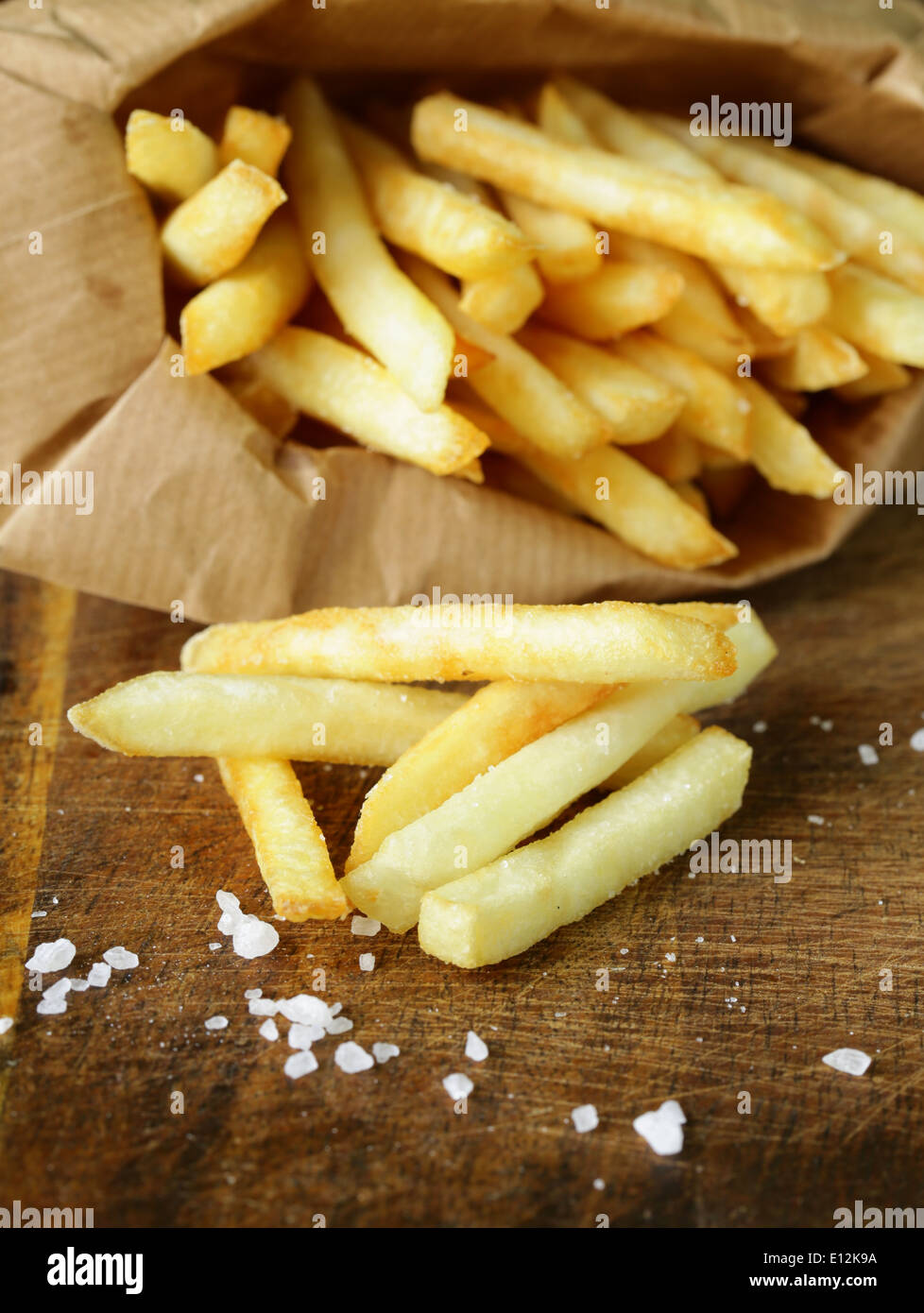 Pommes frites traditionnelles avec du sel sur fond de bois Banque D'Images