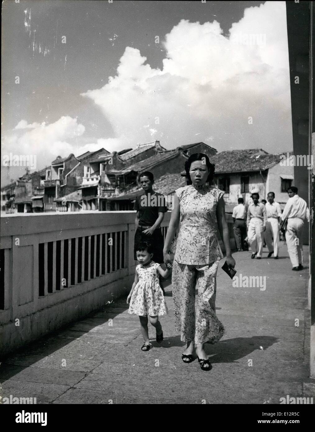 25 février 2012 - Changement de la mode féminine à Singapour : la plupart des femmes plus jeunes à Singapour comme à s'habiller dans le style occidental. D'autres compromis en portant le ''shong-sam'', une robe moulant avec un côté fendu jusqu'à la cuisse sur les deux côtés. Les femmes plus âgées à conserver la tunique chinoise et d'une presse à pantalons comme cette femme. L'enfant est habillé de façon normale à l'Ouest Banque D'Images