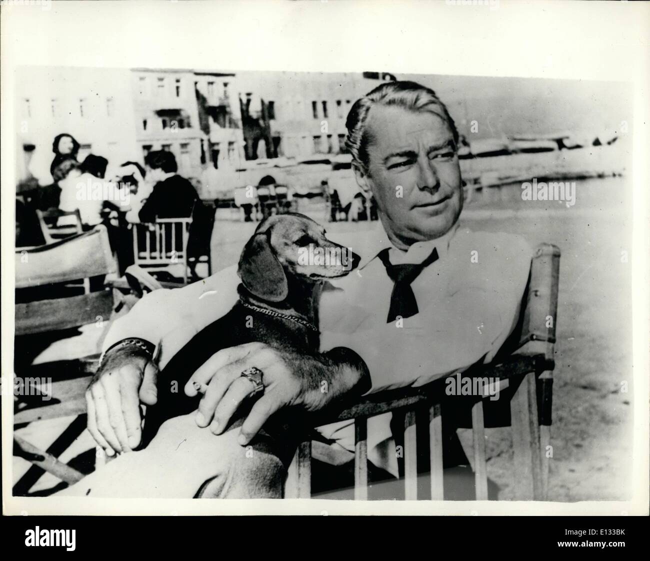 Le 26 février 2012 - Hollywood film star Alan Ladd se détend avec son chien de compagnie, à la terrasse d'un café sur le rivage à l'île grecque d'Hydra après l'achèvement des photos d'extérieur du film ''un garçon sur un Delphin'' qui stars Alan Lad, Sophia Loren et Clifton Webb. D'autres scènes sont filmées sur l'Acropole. Banque D'Images