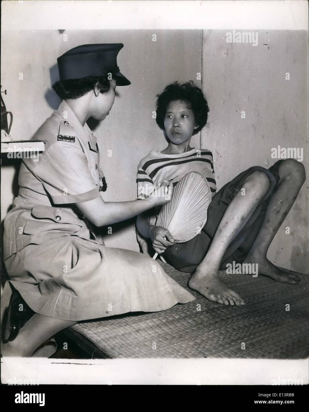 Mar. 22, 2012 - une jeune femme de 27 ans venant de Shanghai, est tout juste d'une herpin daze. Ses jambes sont une masse de commissions paritaires de l'aiguille où elle a injecté de l'héroïne et de l'eau distillée. Elle comprend peu, regardant fixement la policewoman, montrant une hypdermic rh aiguille trouvé sur le haut d'un mur de briques à l'extérieur de sa hutte. C'est une cachette favorite. Elle fans elle-même lentement. Elle a même la nuit s'est désintégré en tant que femme. Elle mange peu, à l'aide de l'argent pour l'héroïne. Incapable de travailler, elle gagne de l'argent à partir des visites de coolies (1/3d'heure) ou un petit paquet d'héroïne Banque D'Images