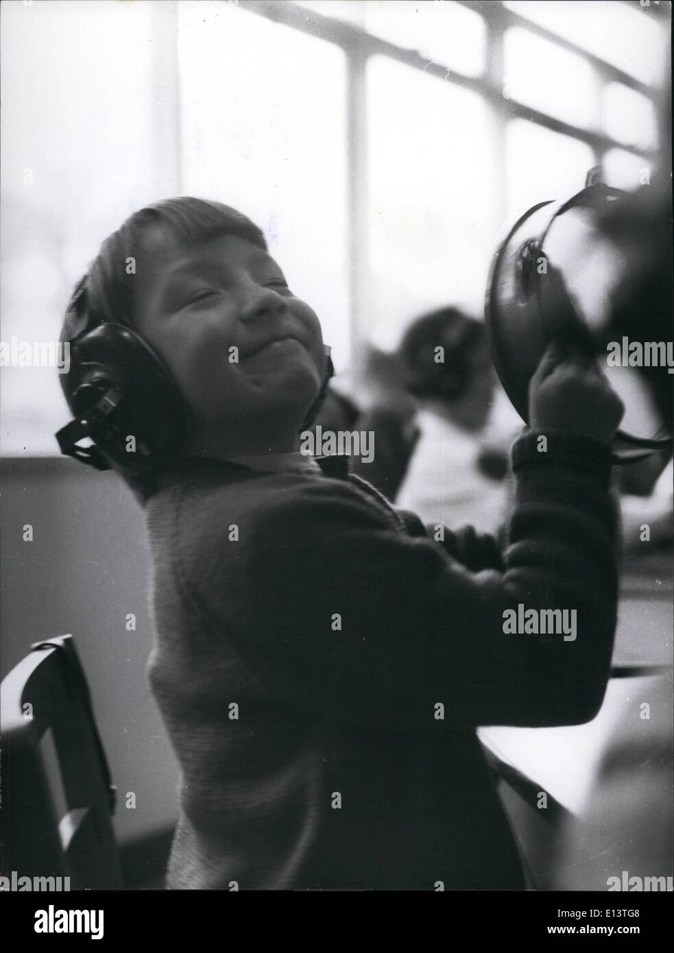 27 mars 2012 - Pure Bliss pour cette jeune Mademoiselle elle peut entendre la musique : huit ans Anita Taylor, de l'audition de la musique à partir d'un enregistrement sur son oreille un téléphone, sièges sur les barres avec un Tamborine. Peu d'Anita est un des plus beaux Smilingest les filles dans l'école. Banque D'Images