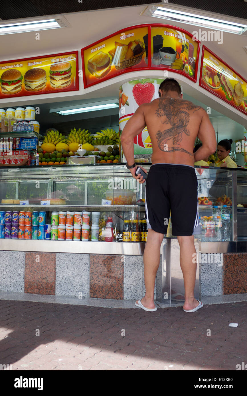 RIO DE JANEIRO, Brésil - 24 octobre 2013 : grand homme brésilien de tatouage est en attente à jus typique de stand. Banque D'Images