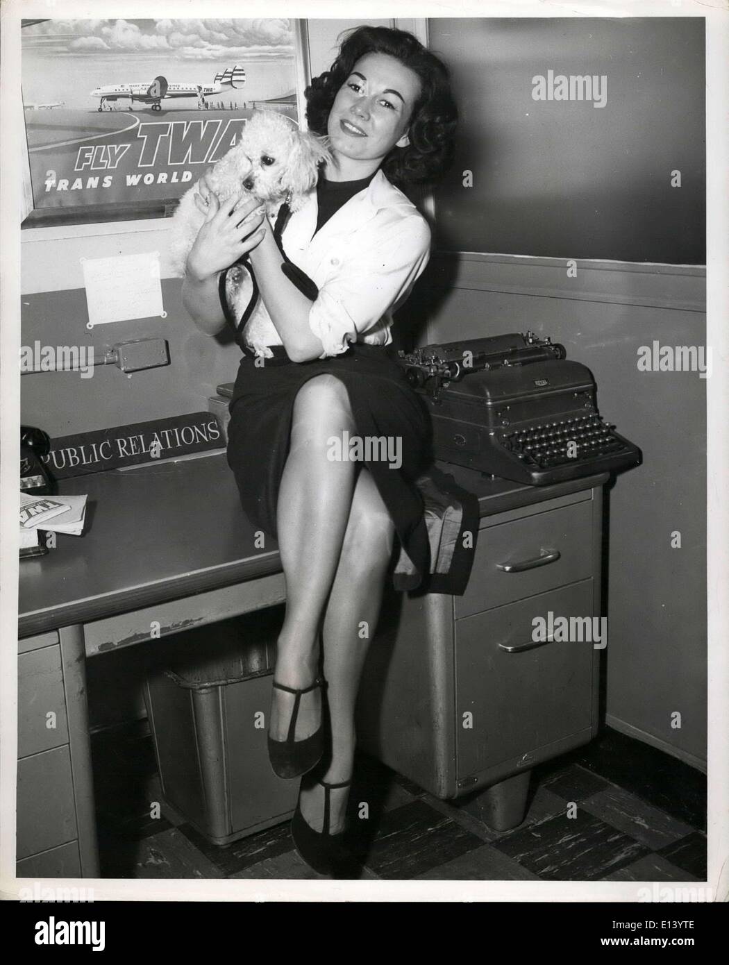 31 mars 2012 - L'aéroport de Idlefild, N.Y : Jody de soutiens D'Amour, le chanteur-modèle, et son compagnon de voyage, caniche français Ganny, sont dirigés pour Chicago VIA TWA. Elle a un engagement de chant à la célèbre Chez Paree dans la Windy City. Banque D'Images