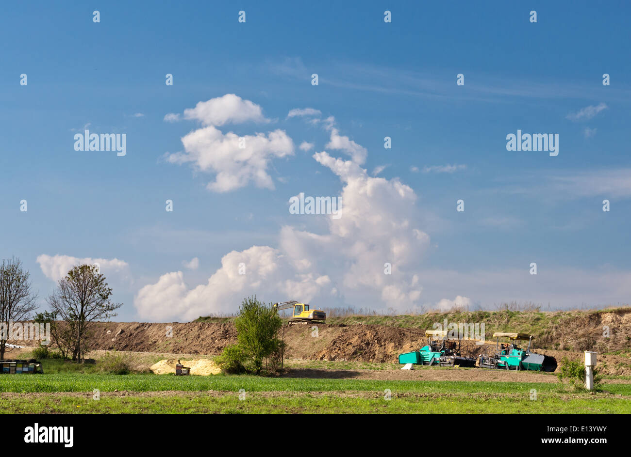 Excavatrice jaune et d'asphalte de la machine dans un nouveau site de construction de routes. Banque D'Images