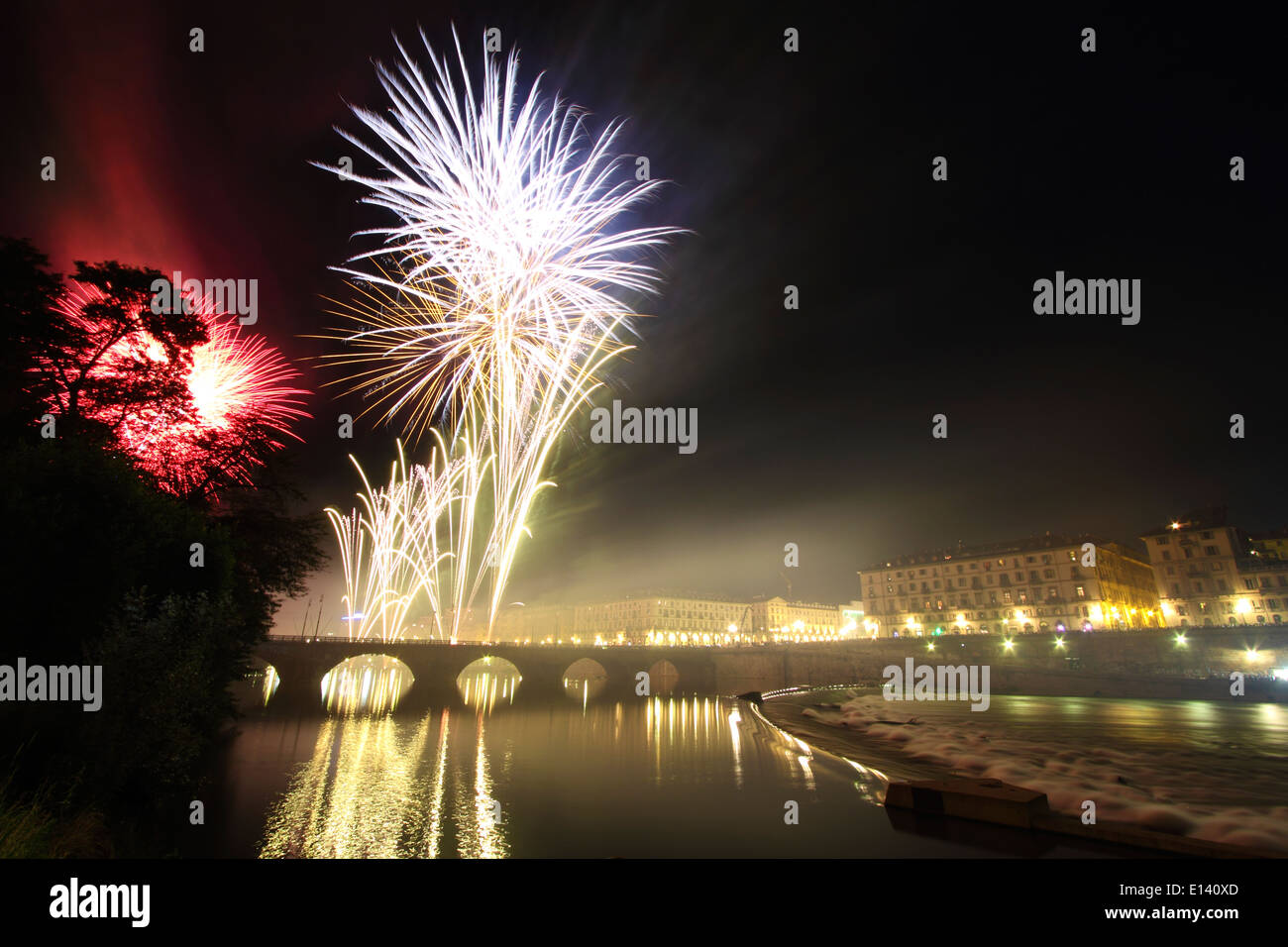 Spectacle de feux d'artifice sur la rivière Po à Turin lors des célébrations de la Saint-Jean. Sur le pont de gauche Vittorio Emanuele I. Banque D'Images