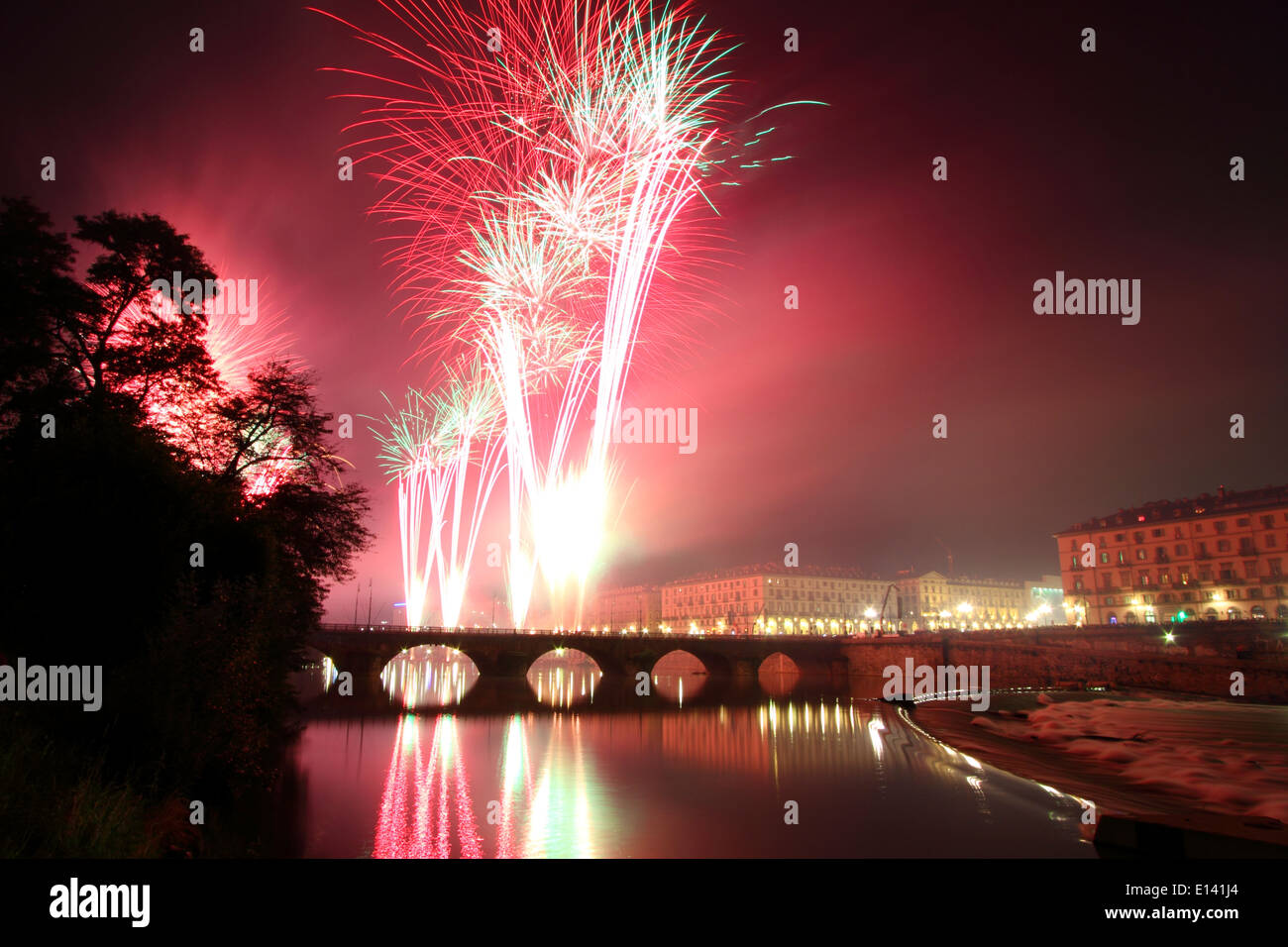 Spectacle de feux d'artifice sur la rivière Po à Turin lors des célébrations de la Saint-Jean. Sur le pont de gauche Vittorio Emanuele I. Banque D'Images