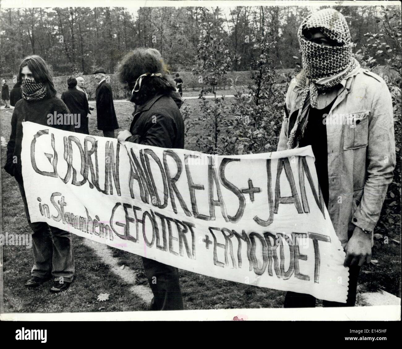 Avril 04, 2012 - Enterrement de la bande Baader-Meinhof terroristes : Les funérailles ont eu lieu le 27 octobre, les trois de tgh reconnu coupable de la bande Baader-Meinhof qui s'est suicidé dans la prison de Stammheim 10 jours age ont été enterrés dans le cimetière de Stuttgart, Andreas Baader, Raspe Jan G., Enssli. La photo montre la Baader-Meinchof avec leurs partisans masqués lecture de l'affiche ; ''Gudrun, Andreas et Jan, ont été torturées et assassinées à Stammheim prison. Banque D'Images Avril 04, 2012 - Enterrement de la bande Baader-Meinhof terroristes : Les funérailles ont eu lieu le 27 octobre, les trois de tgh reconnu coupable de la bande Baader-Meinhof qui s'est suicidé dans la prison de Stammheim 10 jours age ont été enterrés dans le cimetière de Stuttgart, Andreas Baader, Raspe Jan G., Enssli. La photo montre la Baader-Meinchof avec leurs partisans masqués lecture de l'affiche ; ''Gudrun, Andreas et Jan, ont été torturées et assassinées à Stammheim prison. Banque D'Images