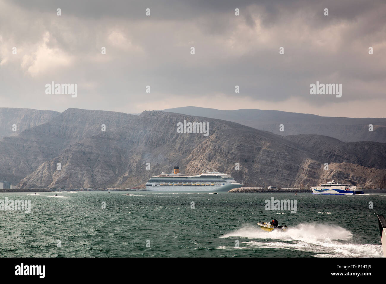 Oman, Khasab, Port, passeurs iraniens apporter des marchandises retour à l'Iran avec de petites embarcations. Bateau de croisière Costa Fortuna Banque D'Images