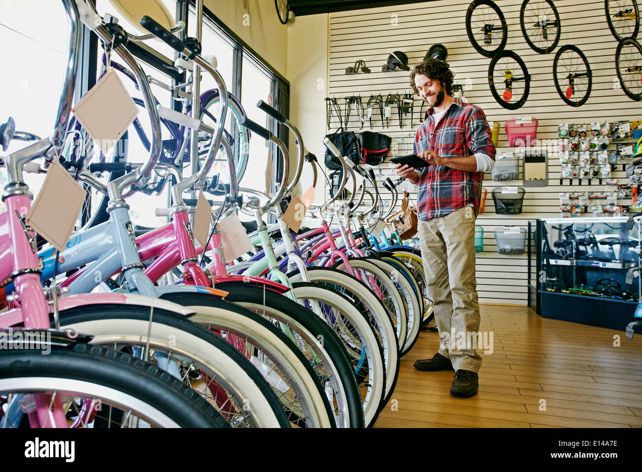 Caucasian man travaillant dans magasin de bicyclettes Banque D'Images