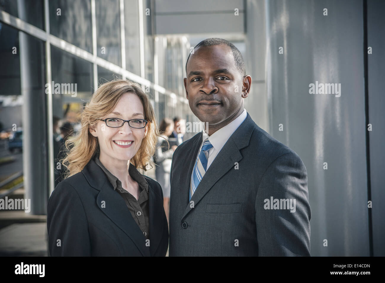 Business people smiling outside office building Banque D'Images