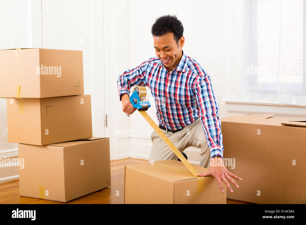 Mixed Race man packing cardboard boxes Banque D'Images