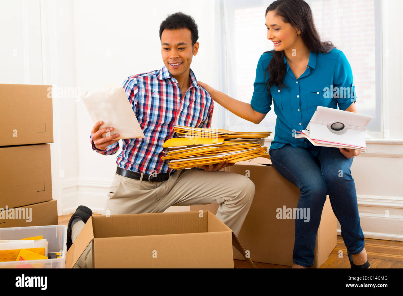 Mixed Race couple packing cardboard boxes Banque D'Images
