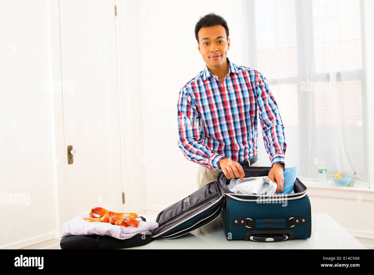 Mixed Race woman packing suitcase Banque D'Images