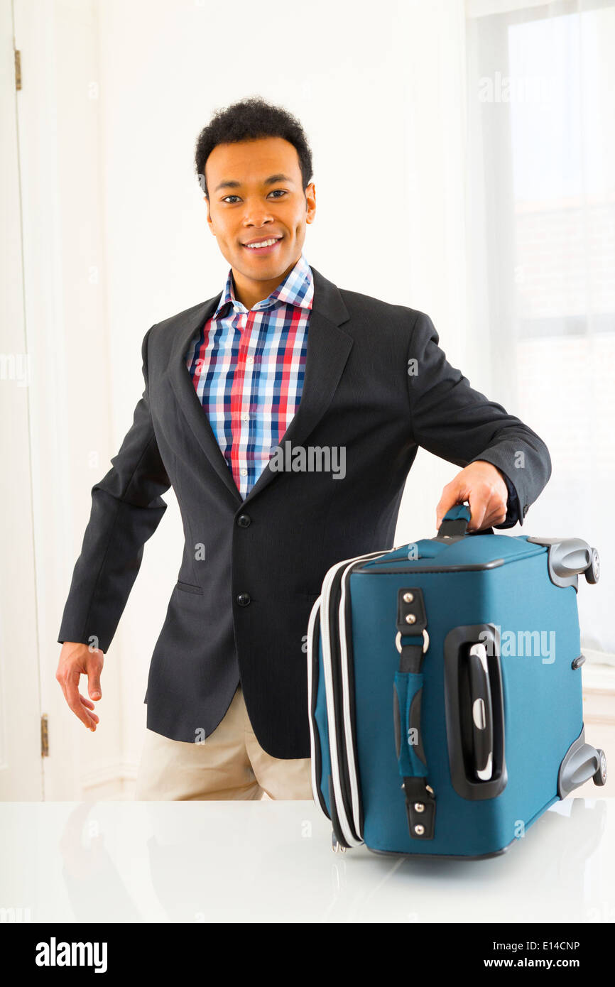 Mixed Race businessman carrying suitcase Banque D'Images