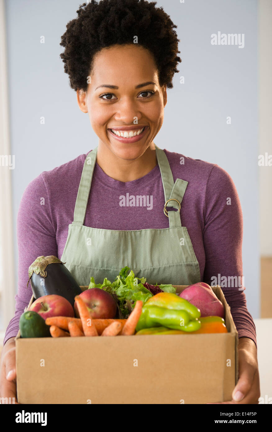 Portrait of Black woman holding box de légumes Banque D'Images
