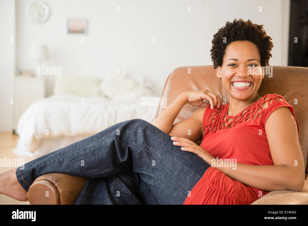 Portrait of smiling black woman in armchair Banque D'Images