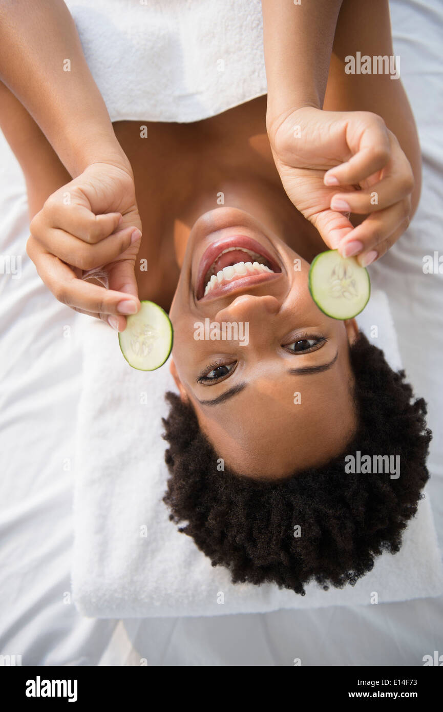 Portrait of smiling black woman holding tranches de concombre Banque D'Images