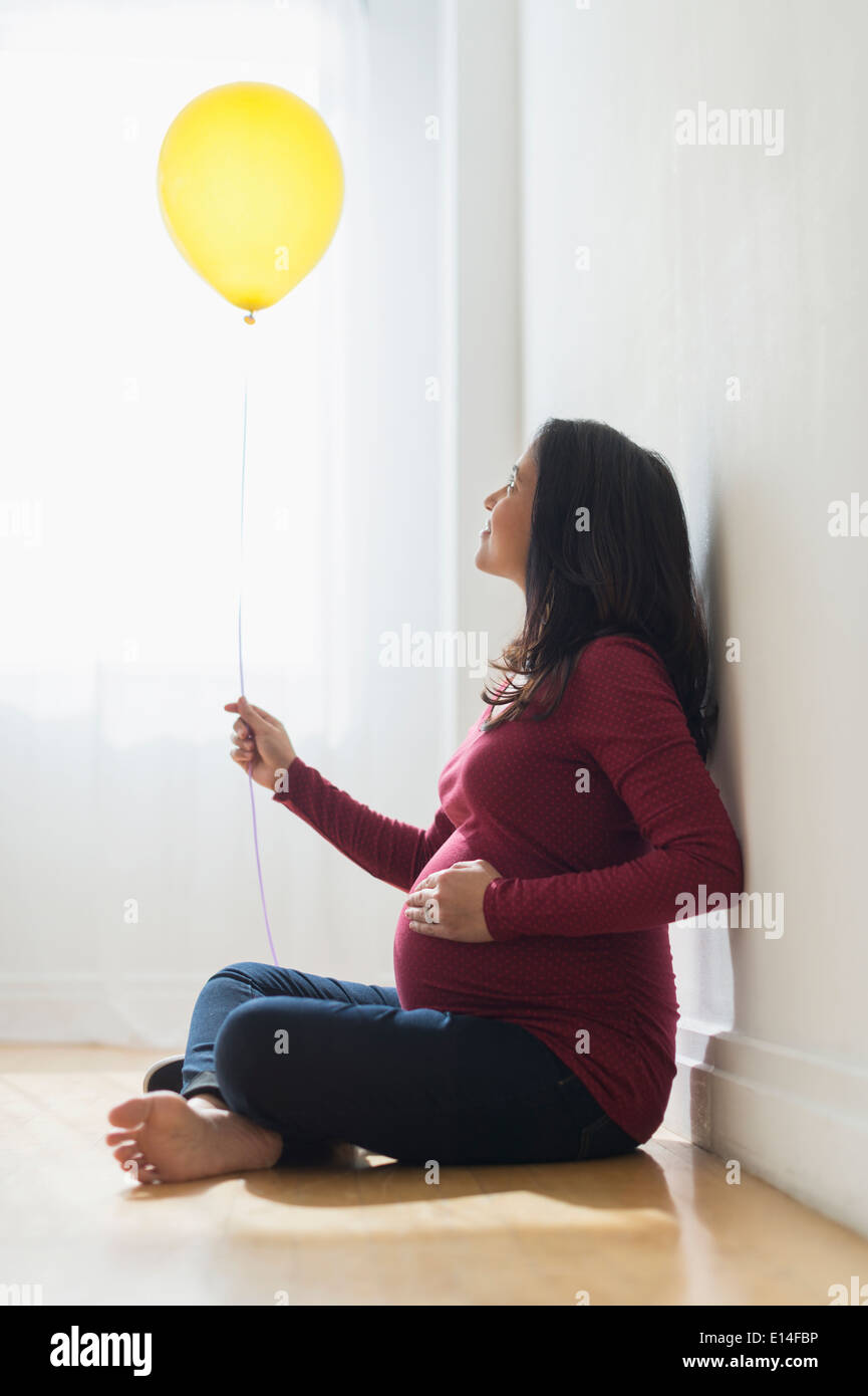 Pregnant Hispanic woman holding balloon Banque D'Images