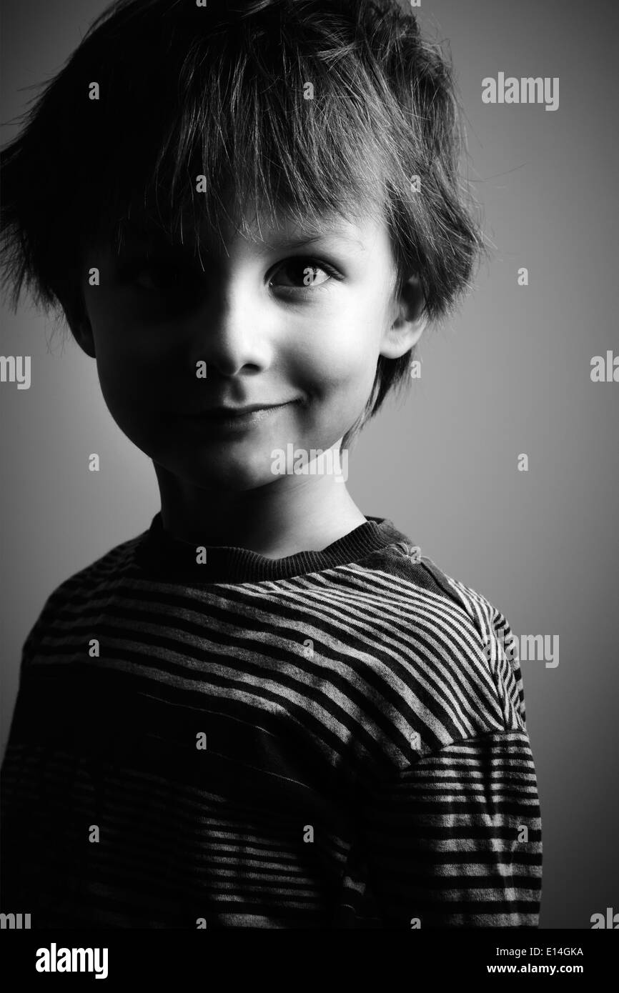 Portrait of a Boy smiling 6-7 ans, en partie dans l'ombre Banque D'Images