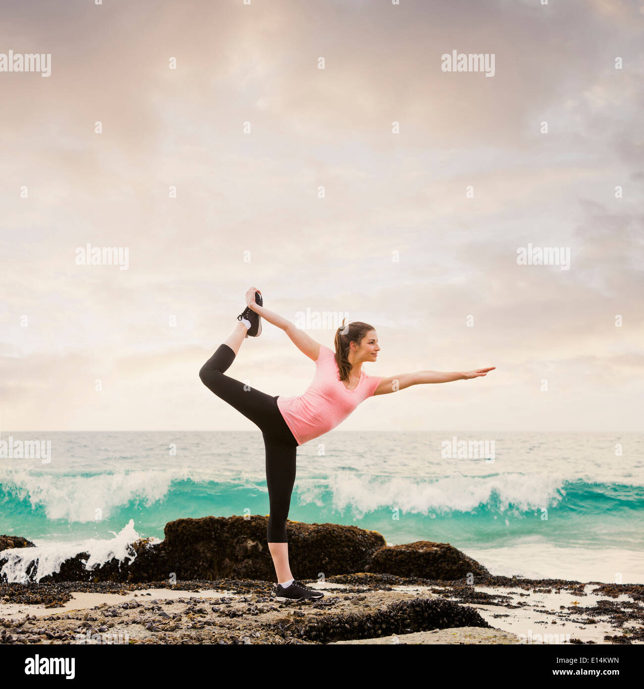 Caucasian woman stretching on beach Banque D'Images