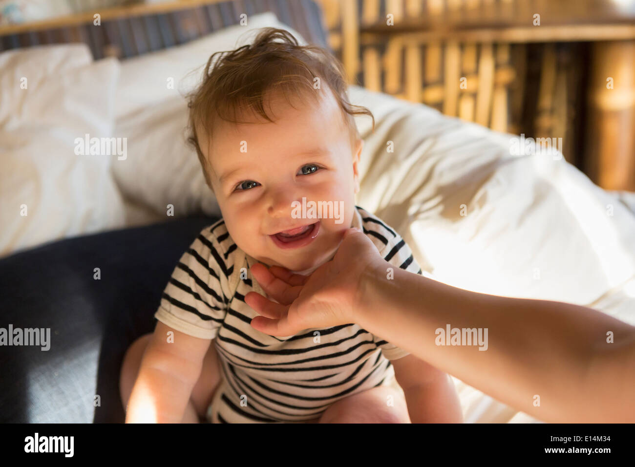 Caucasian baby laughing on bed Banque D'Images