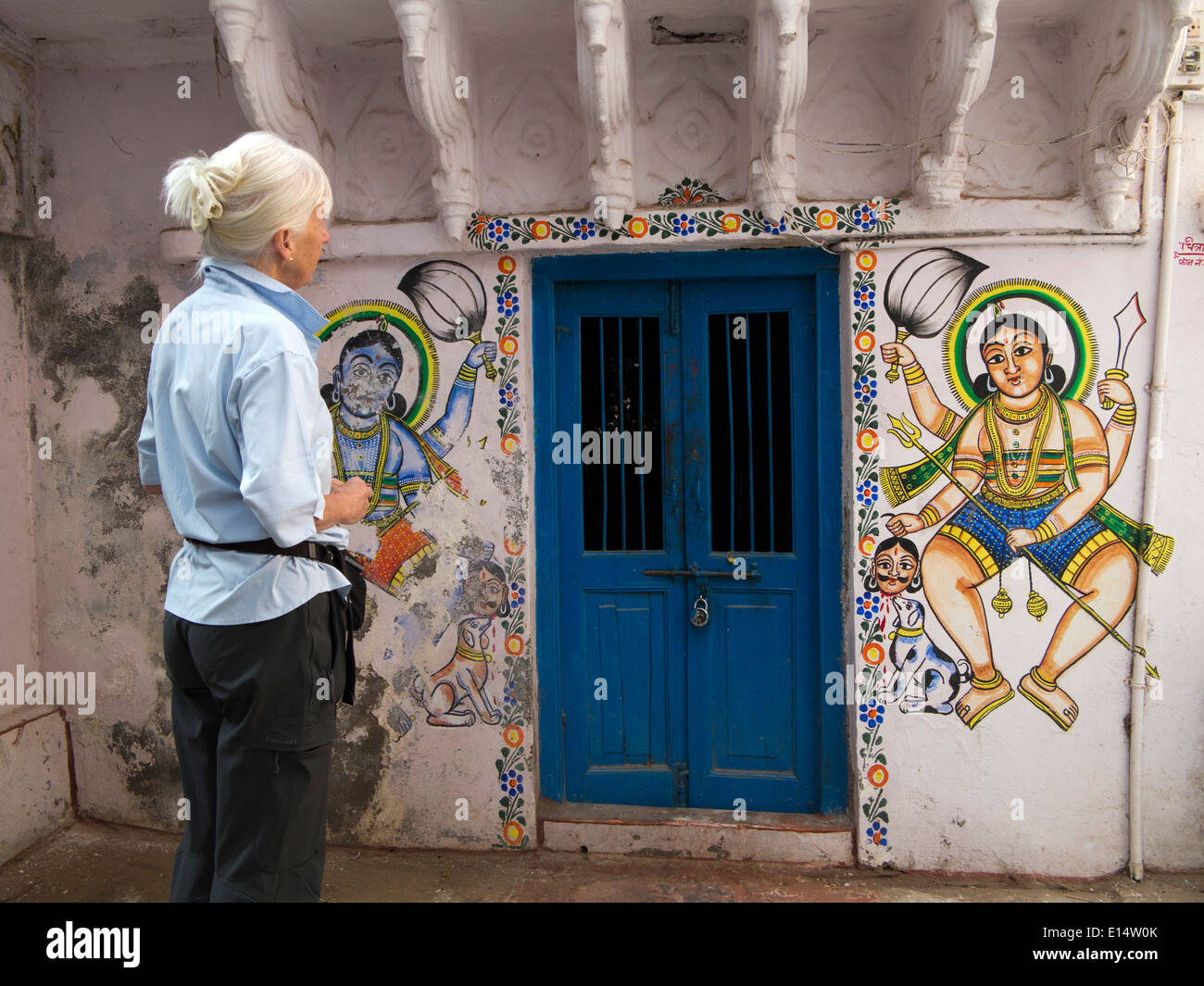 L'Inde, Rajasthan, Udaipur, Rajasthan Folk Art, Peintures murales de divinités à côté de très petite porte bleue Banque D'Images