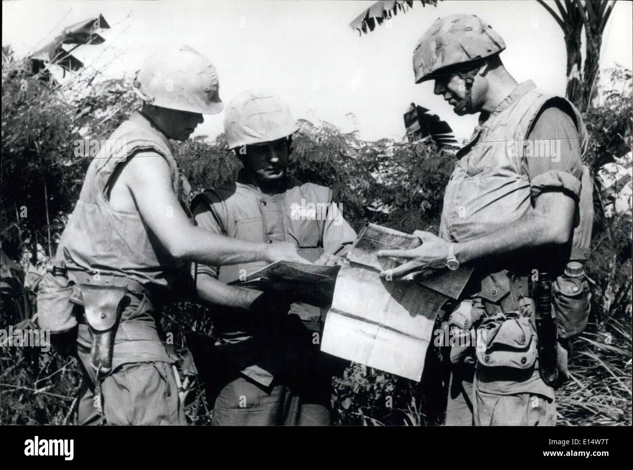 18 avril 2012 - CONFÉRENCE DE LA JUNGLE : Trois officiers américains vérifient leurs cartes dans une jungle pendant une poussée dans la brousse à la recherche du Viet Cong. Les officiers portent leur bulled-preuve des vestes. Banque D'Images