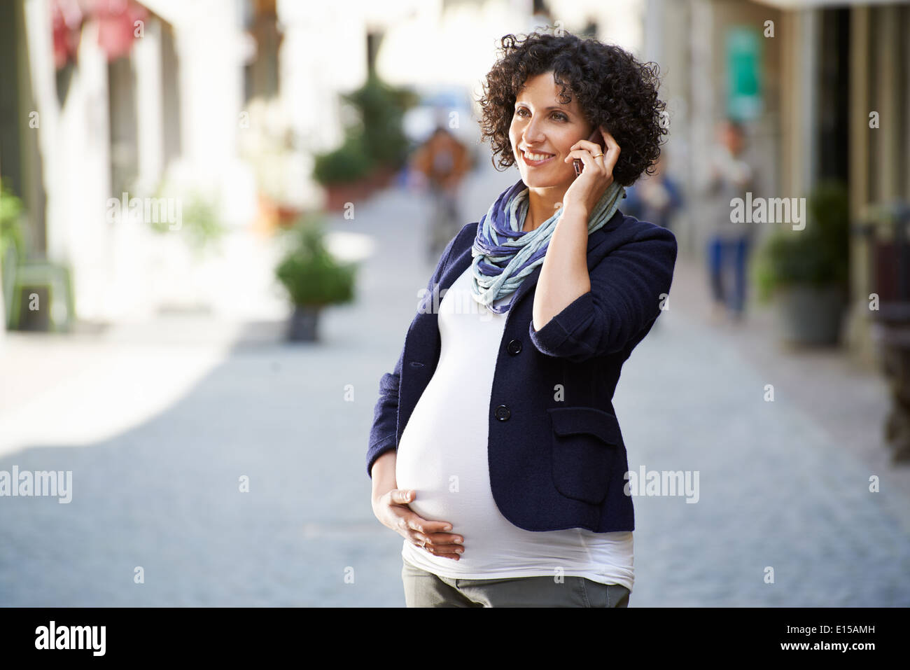 Les gens heureux et le mode de vie avec femme enceinte parle avec cell phone in city street Banque D'Images