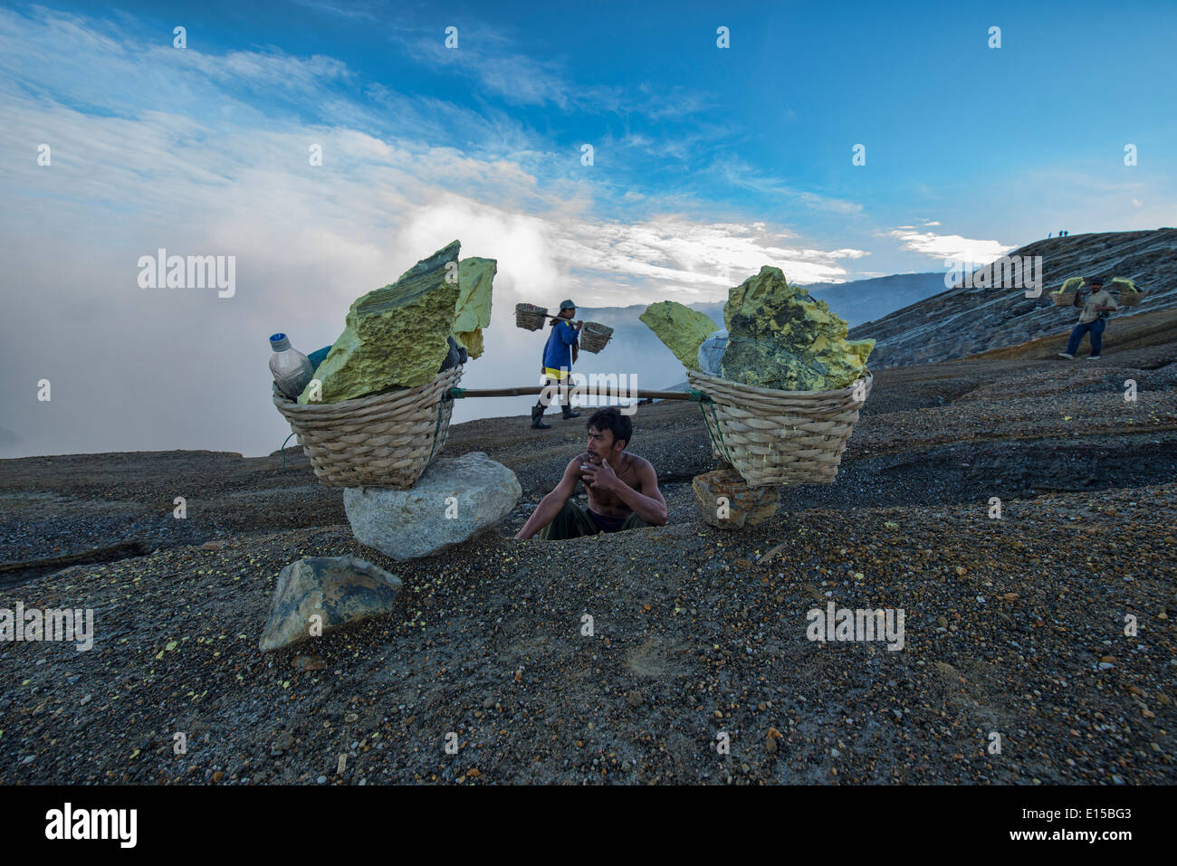 Mineur de soufre en faisant une pause dans le Kawah Ijen cratère volcanique, Java, Indonésie Banque D'Images